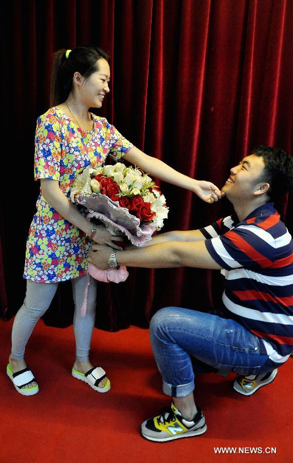 A bride and a bridegroom enjoy themselves after registering as a married couple at a marriage registry in Jinan City, east China's Shandong Province, May 20, 2013. As the pronunciation of the date number "520" sounds similiar to "I love you" in Chinese, many people chose to register as couples on Monday. (Xinhua/Zhao Xiaoming)