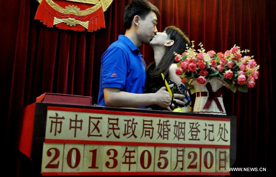 A bride and a bridegroom kiss after registering as a married couple at a marriage registry in Jinan City, east China's Shandong Province, May 20, 2013. As the pronunciation of the date number "520" sounds similiar to "I love you" in Chinese, many people chose to register as couples on Monday. (Xinhua/Zhao Xiaoming)