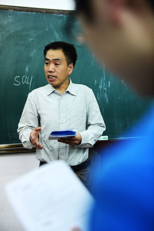 Zhao Dushun, a 50-year-old security guard, participates in the activity organized by an English club in the in Heilongjiang Engineering College on May 10, 2013. As an English enthusiast, Zhao has studied English by himself for 30 years. Now he works as a security guard in Heilongjiang Engineering College and becomes a "star member" of the English club on campus. (Xinhua/Wang Kai)