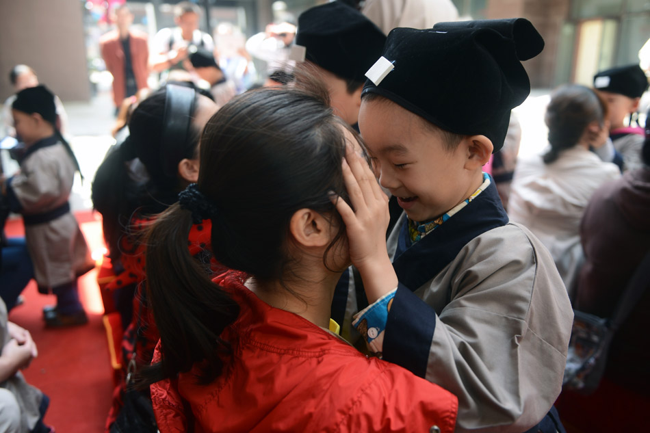 A child plays game with his mother at a training class in Changchun, northeast China's Jilin province, May 11, 2013. The class, held on weekends, teaches children aged 3 to 6 years traditional Chinese culture, including etiquette and Han Chinese costumes. (Xinhua/Lin Hong)