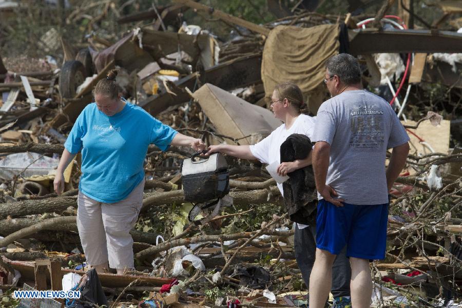 A resident hands a cooler to her sister in the wreckage in Shawnee, Oklahoma, the United States, May 20, 2013. Two men were confirmed dead after tornadoes hit the U.S. state of Oklahoma, officials said Monday. Tornadoes ravaged portions of central Oklahoma on Sunday, according to media reports. (Xinhua/Marcus DiPaola) 