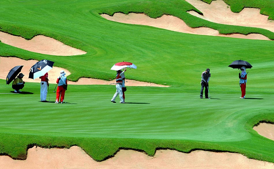 Visitors play golf on May 18, 2013, at Guanlan Lake Holiday Resort in Haikou city, Hainan province.  (Photo/Xinhua)