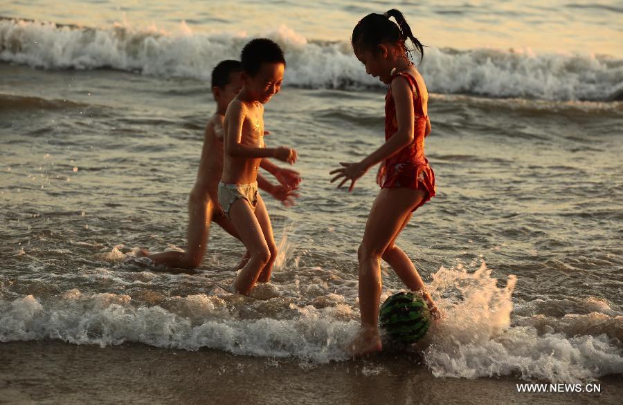 Children play along the seaside in Sanya, south China's Hainan Province, May 20, 2013. (Xinhua/Chen Wenwu)