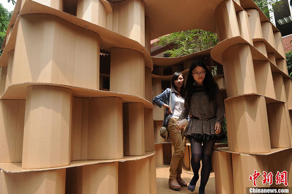 Students look a round a house made of paper boxes at Chongqing University in Southwest China's Chongqing Municipality, May 20, 2013. (CNS/Chen Chao) 