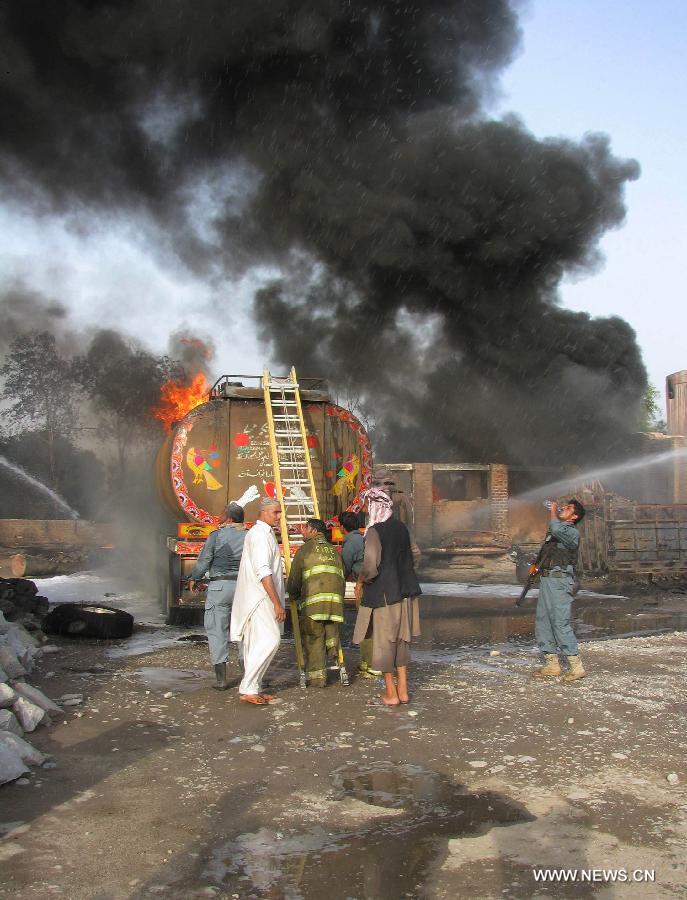 Firefighters work to extinguish fire at a parking lot where five oil trucks caught fire in Jalalabad, capital city of eastern Afghan province of Nangarhar on May 20, 2013. At least one person was killed in the fire on Monday afternoon. Police officials ruled out involvement of militants in the incident. (Xinhua/Tahir Safi)