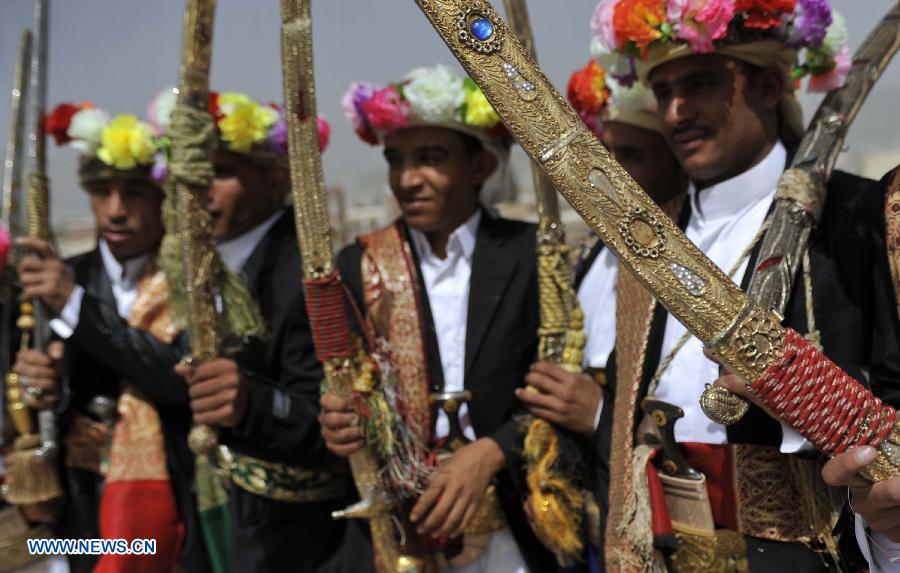 Grooms in traditional wedding dresses hold their swords during a group wedding ceremony in Sanaa, Yemen, on May 20, 2013. A total of 200 couples attend a group wedding organized by the Yemeni government, all of whom are orphans growing up in government-run centers. (Xinhua/Mohammed Mohammed)