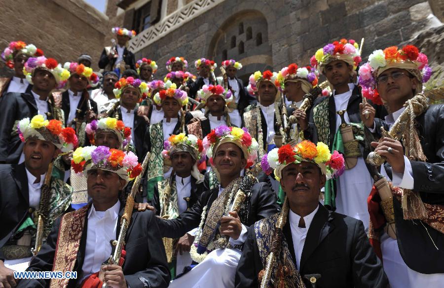 Grooms in traditional wedding dresses hold their swords during a group wedding ceremony in Sanaa, Yemen, on May 20, 2013. A total of 200 couples attend a group wedding organized by the Yemeni government, all of whom are orphans growing up in government-run centers. (Xinhua/Mohammed Mohammed)