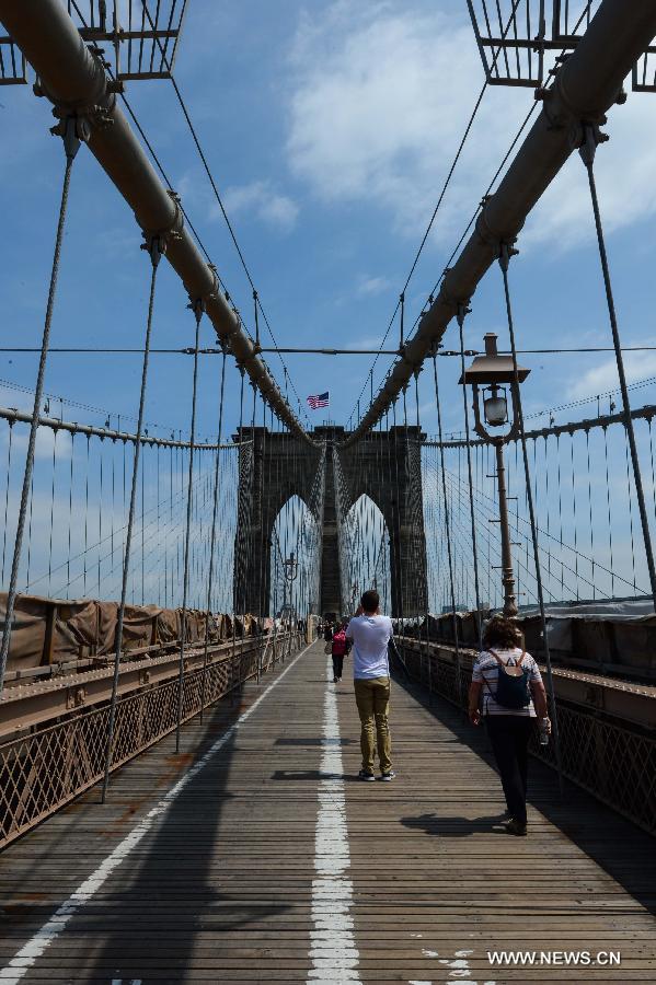 People walk on the Brooklyn Bridge in New York, the United States, on May 20, 2013. The Brooklyn Bridge, opened on May 24, 1883, will celebrate its 130th birthday this week. (Xinhua/Niu Xiaolei)