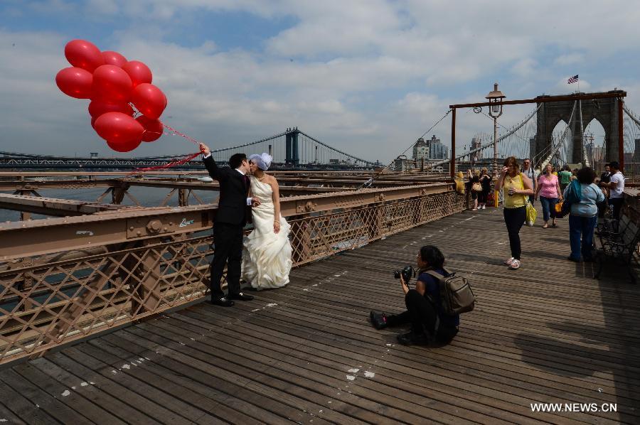 A couple pose for their wedding pictures on the Brooklyn Bridge in New York, the United States, on May 20, 2013. The Brooklyn Bridge, opened on May 24, 1883, will celebrate its 130th birthday this week. (Xinhua/Niu Xiaolei)