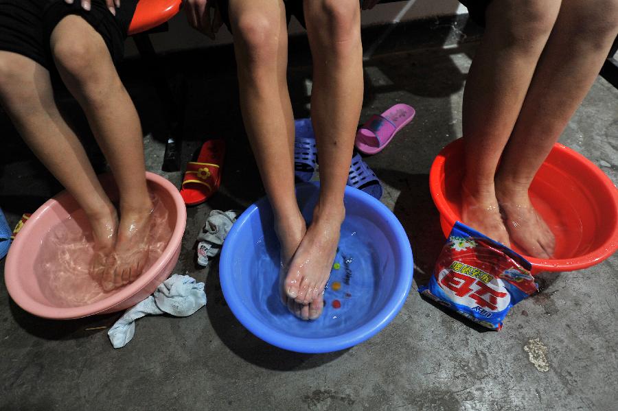 Children of an acrobatic troupe wash their feet at their dorm in Yinchuan, capital of northwest China's Ningxia Hui Autonomous Region, May 20, 2013. Established in 1958, the acrobatics troupe was now affiliated with Ningxia Yinchuan Art Theatre. During the past few years, over 30 children between 5 and 13 years old have been admitted to the troupe to exercise acrobatics. In order to perform well on the stage, they exert much effort on exercising. Besides, they also learn general courses such as maths, Chinese and English. Yao Xing, deputy principal of the troupe, said that acrobatics requires painstaking effort, which will pay off one day. (Xinhua/Peng Zhaozhi)