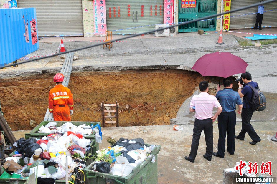 Rescuers work at the accident site where a road cave-in occurred in Huamao Industrial Park in Shenzhen, south China's Guangdong Province, May 21, 2013. The accident occurred around 9:19 p.m. (1319 GMT) on May 20. As of 4:30 p.m. (0830 GMT) Tuesday, five bodies had been retrieved from a pit measuring three to four meters deep. Search and rescue efforts are under way. (Xinhua)