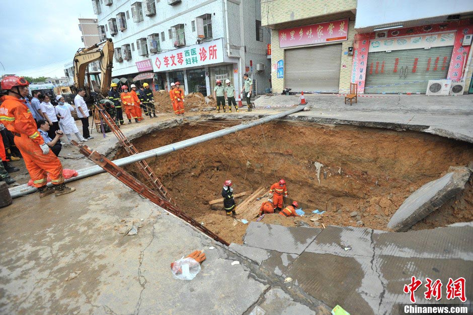 Rescuers work at the accident site where a road cave-in occurred in Huamao Industrial Park in Shenzhen, south China's Guangdong Province, May 21, 2013. The accident occurred around 9:19 p.m. (1319 GMT) on May 20. As of 4:30 p.m. (0830 GMT) Tuesday, five bodies had been retrieved from a pit measuring three to four meters deep. Search and rescue efforts are under way. (Xinhua)