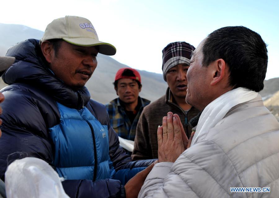 Xia Jianfeng (R) expresses his gratitude to the rescuers in the base camp on Mount Qomolangma (Mount Everest), southwest China's Tibet Autonomous Region, May 19, 2013. Xia Jianfeng, a member of a commercial climbing team who suffered from cerebral edema on the altitude of 8, 650 meters, was rescued to the base camp on May 19. The successful rescue made a miracle as it took place in such high altitude of the mountain. As increasingly more people come to climb the world's highest mountain in recent years, the rescue system here is also rapidly improved for the safety of climbers. (Xinhua/Suolang Luobu)