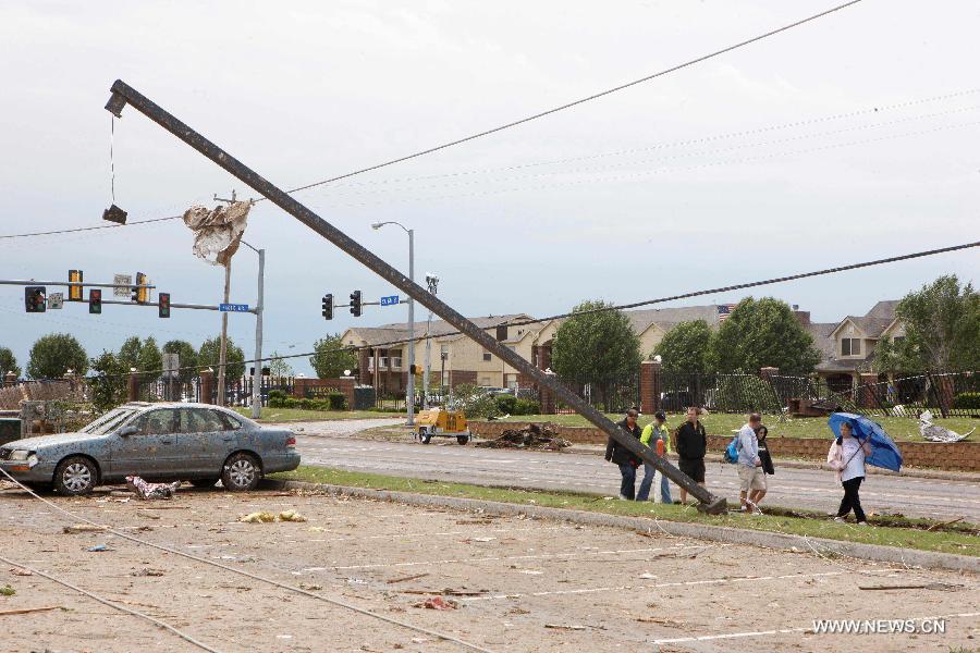 Residents walk through a destroyed neighborhood in Moore, Oklahoma, May 21, 2013, one day after a tornado moved through the area. A powerful tornado attacked on Monday afternoon the southern suburbs of the Oklahoma City, capital of the U.S. state of Oklahoma, killing at least 24 people, including 9 children. (Xinhua/Song Qiong) 