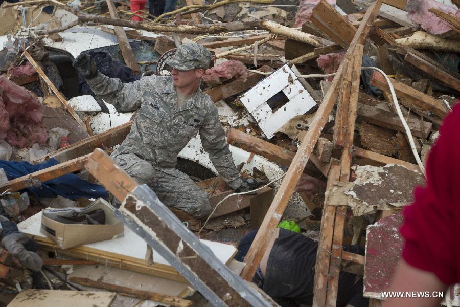 A U.S. Air Force member calls for assistance while searching the rubble after a tornado in Moore, Oklahoma, the United States, on May 20, 2013. Twenty-four people were killed and 237 others injured when a massive tornado blasted the southern suburbs of Oklahoma City, the capital of the U.S. state of Oklahoma, on Monday, state officials said Tuesday. (Xinhua/Marcus DiPaola) 