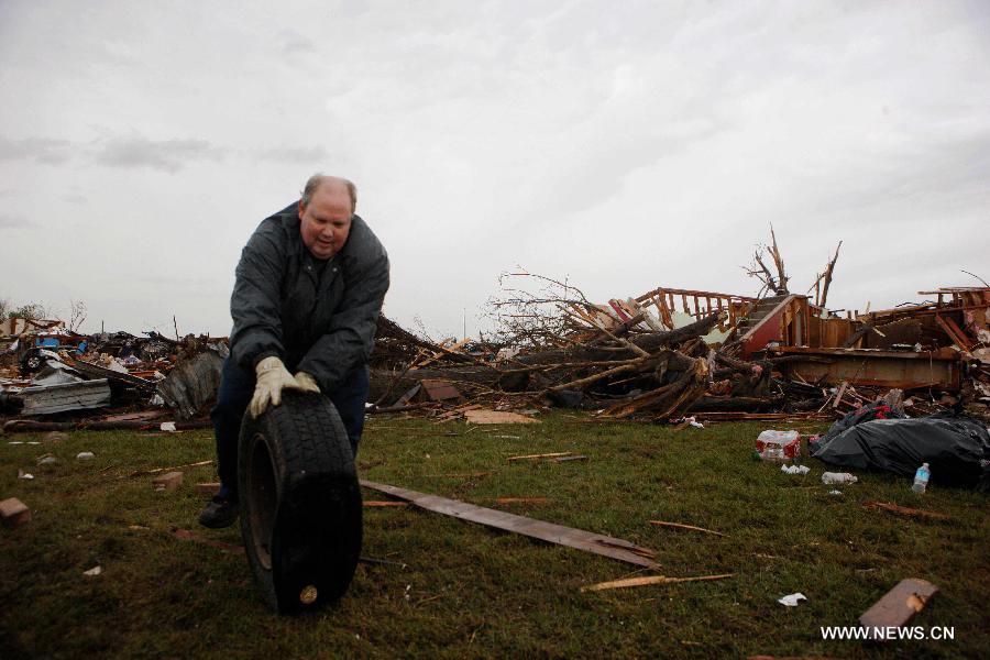 Resident Wes cleans the wreckage after a tornado in Moore, Oklahoma, the United States, on May 21, 2013. Twenty-four people were killed and 237 others injured when a massive tornado blasted the southern suburbs of Oklahoma City, the capital of the U.S. state of Oklahoma, on Monday, state officials said Tuesday. (Xinhua/Song Qiong) 