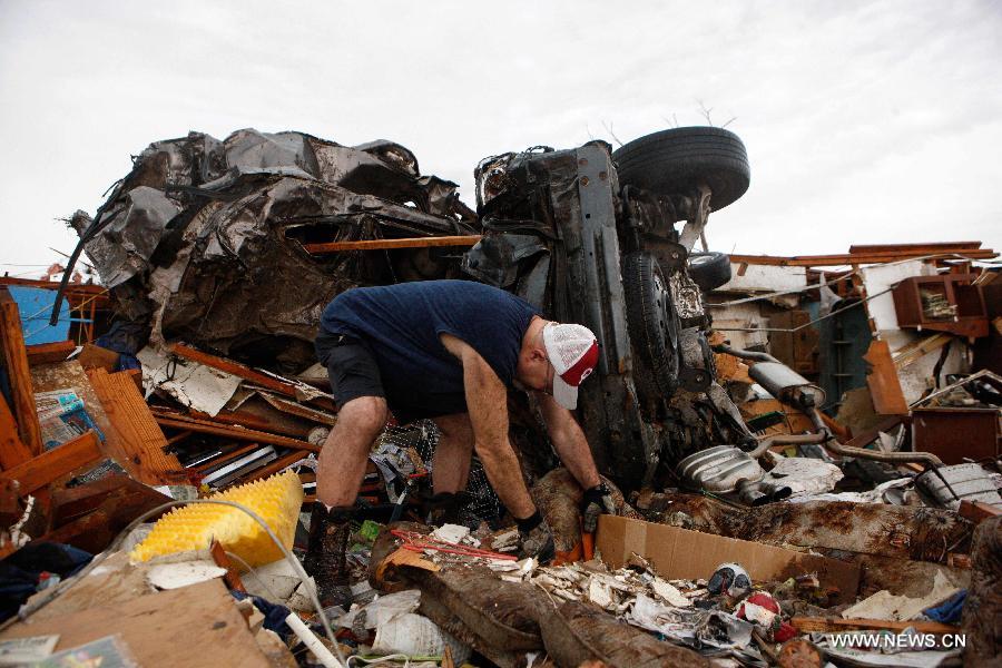 Resident Johnson cleans the wreckage after a tornado in Moore, Oklahoma, the United States, on May 21, 2013. Twenty-four people were killed and 237 others injured when a massive tornado blasted the southern suburbs of Oklahoma City, the capital of the U.S. state of Oklahoma, on Monday, state officials said Tuesday. (Xinhua/Song Qiong) 