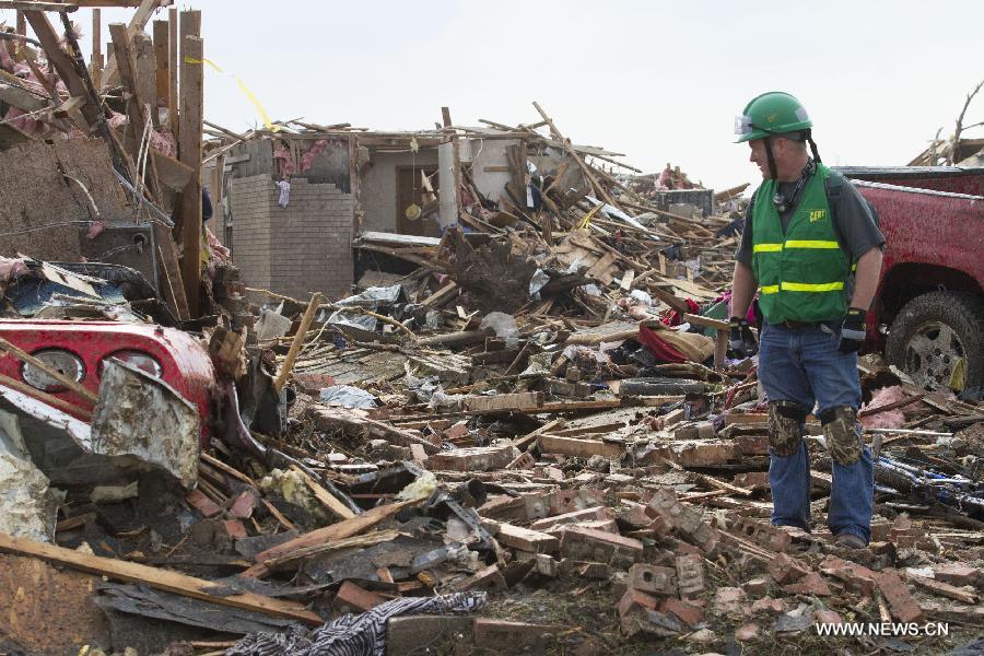 A rescuer searches for survivors after a tornado in Moore, Oklahoma, the United States, on May 20, 2013. Twenty-four people were killed and 237 others injured when a massive tornado blasted the southern suburbs of Oklahoma City, the capital of the U.S. state of Oklahoma, on Monday, state officials said Tuesday. (Xinhua/Marcus DiPaola) 