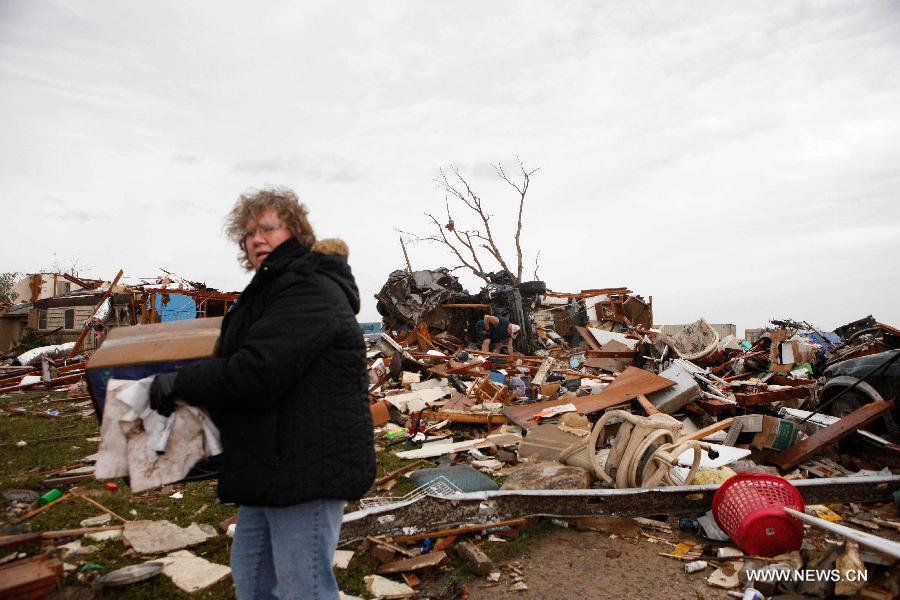 Resident Mrs. Johnson cleans the wreckage after a tornado in Moore, Oklahoma, the United States, on May 21, 2013. Twenty-four people were killed and 237 others injured when a massive tornado blasted the southern suburbs of Oklahoma City, the capital of the U.S. state of Oklahoma, on Monday, state officials said Tuesday. (Xinhua/Song Qiong) 