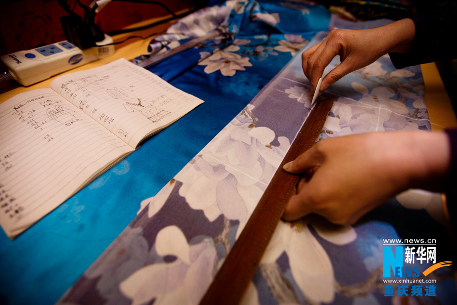 Shi Yuhong tailors a cheongsam in Chongqing on March 29, 2013. She has been making cheongsam for more than 10 years. (Photo/Xinhua)
