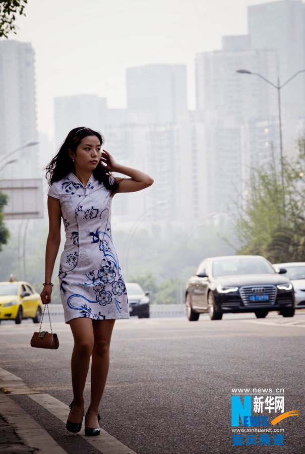 Milliy in Cheongsam walks in the street in Jiangbei District of Chongqing on April 18, 2013. Milliy said her love to cheongsam came from the love to classic culture. (Photo/Xinhua)