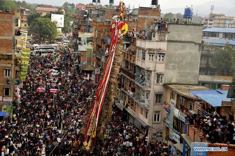 The Nepalese priest climbs on top of the chariot to perform coconut dropping rituals during the Rato Machhindranath chariot festival in Lagankhel, on the outskirts of Kathmandu, Nepal, May 21, 2013. The Nepalese worships Machhindranath for rain, good crop and prosperity. (Xinhua/Sunil Pradhan) 