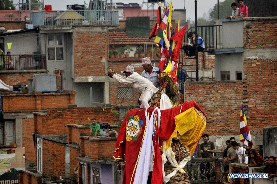 The Nepalese priest shows the coconut to devotees before performing coconut dropping rituals during the Rato Machhindranath chariot festival in Lagankhel, on the outskirts of Kathmandu, Nepal, May 21, 2013. The Nepalese worships Machhindranath for rain, good crop and prosperity. (Xinhua/Sunil Pradhan) 