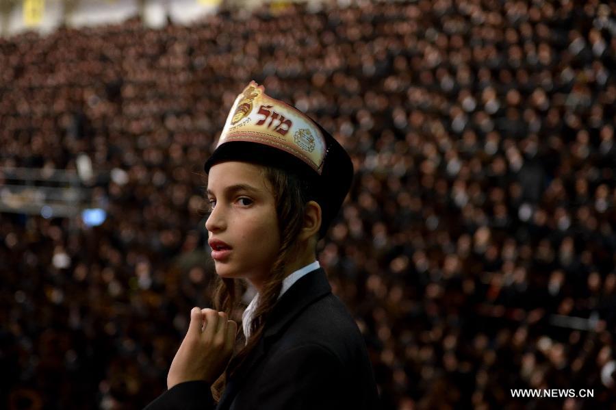 A Jewish boy of the Belz Hasidic Dynasty watches the wedding ceremony of Rabbi Shalom Rokeach, the grandson of the Belz Rabbi Yissachar Dov Rokeach, at the neighbourhood of Kiryat Belz in Jerusalem on May 21, 2013. More than 10,000 Jews participated in the wedding. (Xinhua/Yin Dongxun) 
