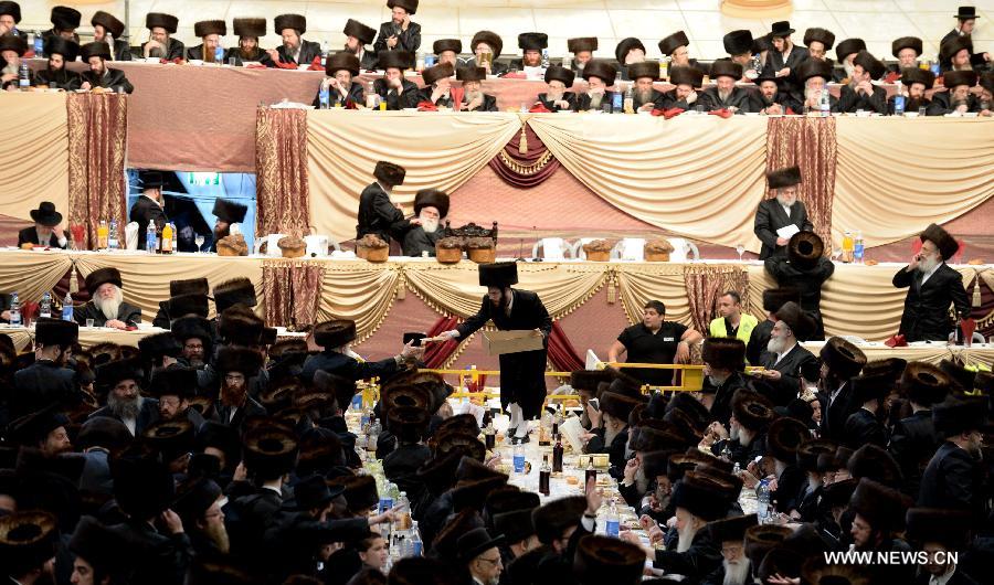 Jews of the Belz Hasidic Dynasty have dinner during the wedding ceremony of Rabbi Shalom Rokeach, the grandson of the Belz Rabbi Yissachar Dov Rokeach, at the neighbourhood of Kiryat Belz in Jerusalem on May 21, 2013. More than 10,000 Jews participated in the wedding. (Xinhua/Yin Dongxun) 