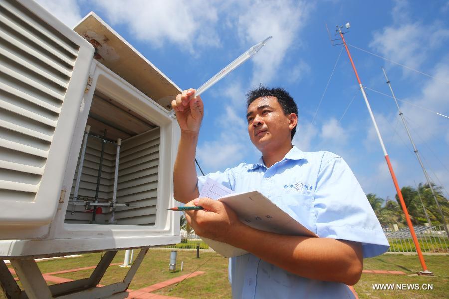 An engineer of the local meteorological authority tests the air temperature in Sansha City, south China's Hainan Province, May 21, 2013. (Xinhua/Zha Chunming)