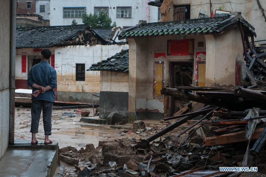 A villager stands in front of houses destroyed by the rainstorm in Guangfu Town of Jiaoling County, Meizhou City, south China's Guangdong Province, May 22, 2013. Meizhou City was hit by a rainstorm on May 19, which killed one people and destroyed 951 houses, leaving 180, 000 people affected in Jiaoling County. (Xinhua/Mao Siqian)