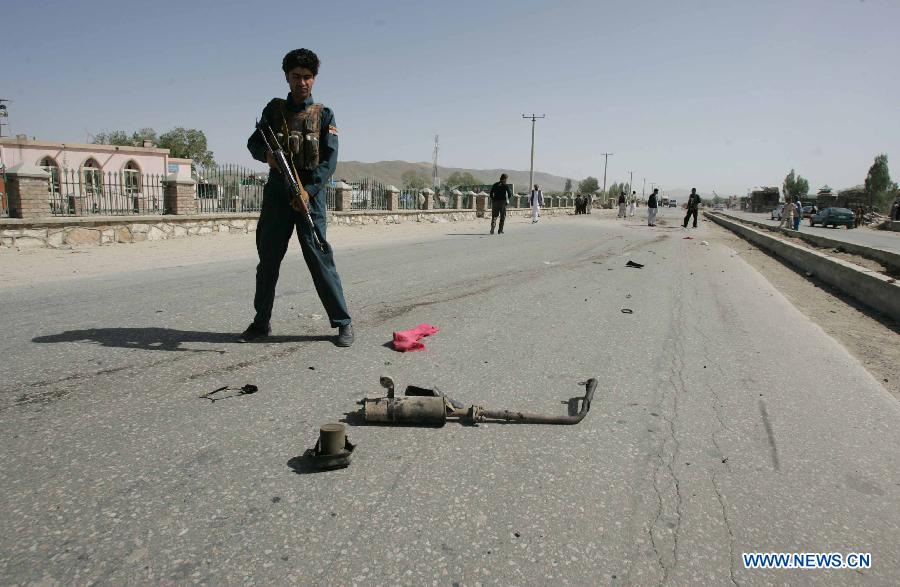 An Afghan policeman inspects the site of blast in Ghazni province in eastern of Afghanistan, on May 22, 2013. One Afghan civilian was killed and five others were wounded Wednesday morning when an improvised bomb went off in Ghazni city, local police said. (Xinhua/Adeb)