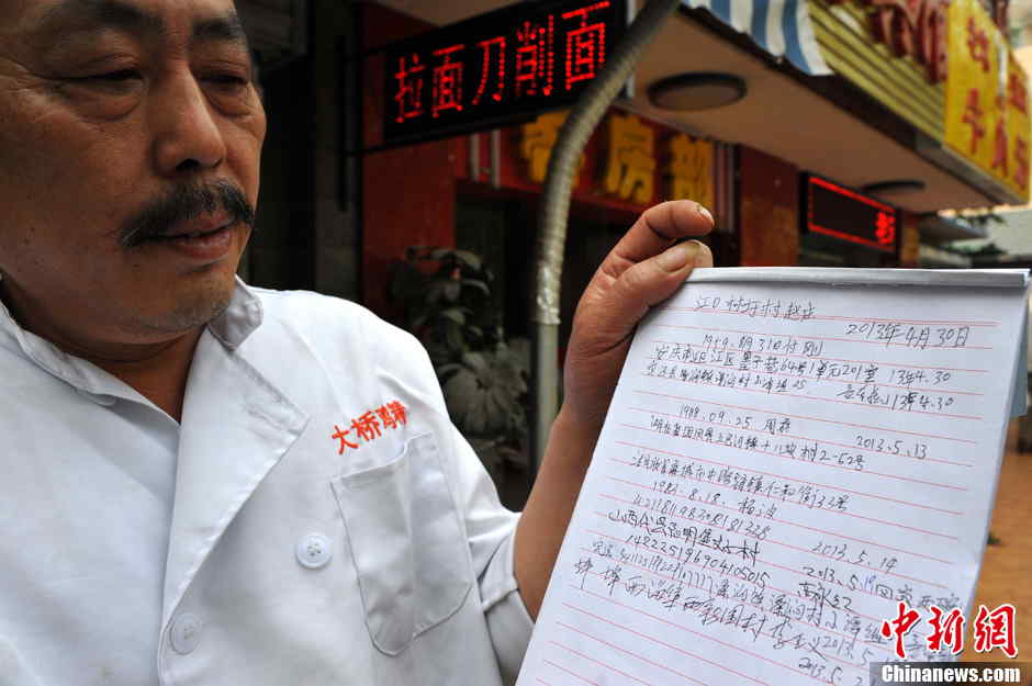 The shop owner presents a record of suspended noodles offered in Hefei, the capital city of central China's Anhui province on May 21, 2013. (Photo by Han Suyuan/ Chinanews.com)