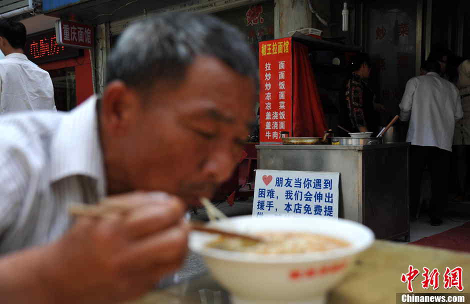 A man has a bowl of hot noodles in Hefei, the capital city of central China's Anhui province on May 21, 2013. (Photo by Han Suyuan/ Chinanews.com)