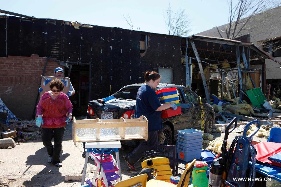 Lawrence family clean up a tornado-destroyed preschool in Moore, Oklahoma, the United States, May 22, 2013. Twenty-four people were killed and 237 others injured when a massive tornado blasted the southern suburbs of Oklahoma City on Monday. (Xinhua/Song Qiong) 