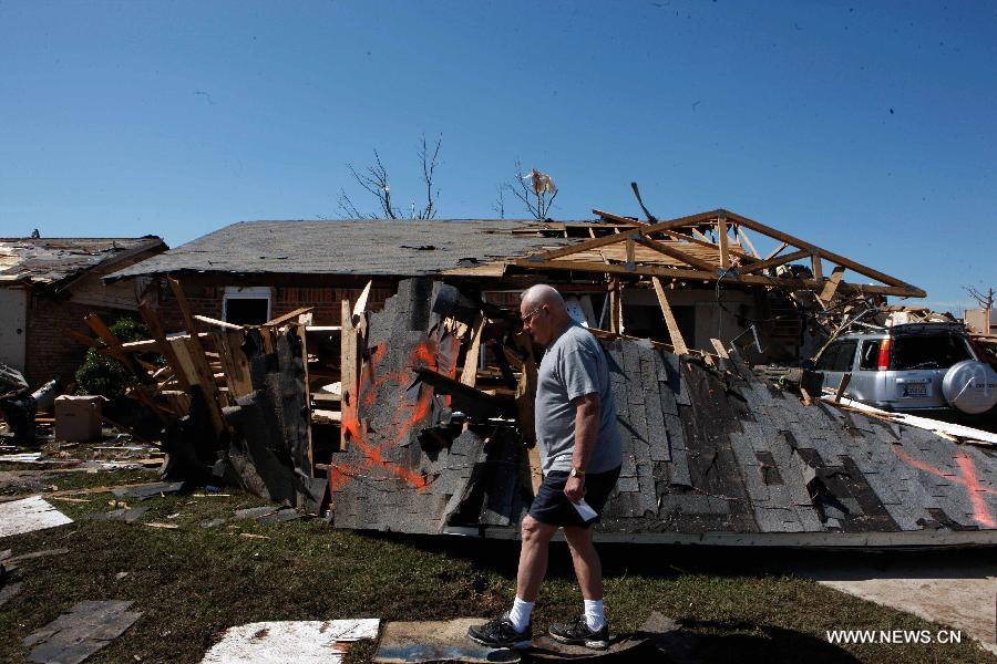 A resident walks pass a tornado-destroyed house in Moore, Oklahoma, the United States, May 22, 2013. Twenty-four people were killed and 237 others injured when a massive tornado blasted the southern suburbs of Oklahoma City on Monday. (Xinhua/Song Qiong) 