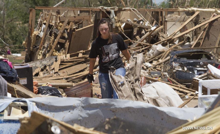 A woman cleans up in a tornado-destroyed neighborhood in Moore, Oklahoma, the United States, May 22, 2013. Twenty-four people were killed and 237 others injured when a massive tornado blasted the southern suburbs of Oklahoma City on Monday, state officials said Tuesday. (Xinhua/Marcus DiPaola) 
