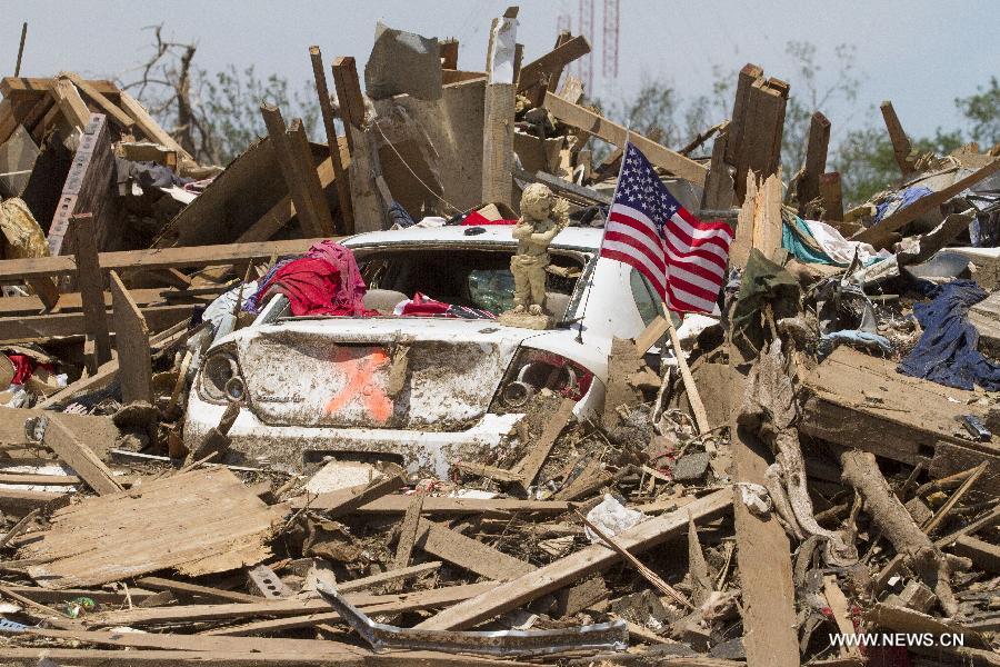 An American flag and baby altar sit are seen in a tornado-destroyed neighborhood in Moore, Oklahoma, the United States, May 22, 2013. Twenty-four people were killed and 237 others injured when a massive tornado blasted the southern suburbs of Oklahoma City on Monday, state officials said Tuesday. (Xinhua/Marcus DiPaola) 