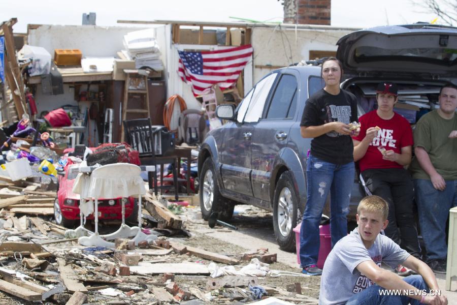 People rest in a tornado-destroyed neighborhood in Moore, Oklahoma, the United States, May 22, 2013. Twenty-four people were killed and 237 others injured when a massive tornado blasted the southern suburbs of Oklahoma City on Monday, state officials said Tuesday. (Xinhua/Marcus DiPaola) 