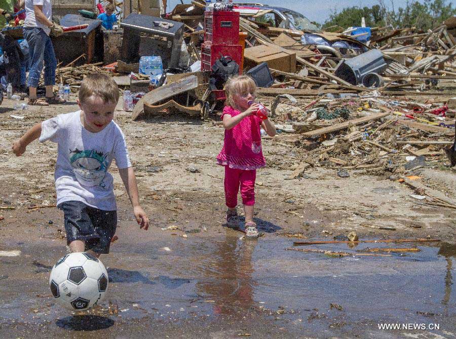 Children play in a tornado-destroyed neighborhood in Moore, Oklahoma, the United States, May 22, 2013. Twenty-four people were killed and 237 others injured when a massive tornado blasted the southern suburbs of Oklahoma City on Monday, state officials said Tuesday. (Xinhua/Marcus DiPaola) 