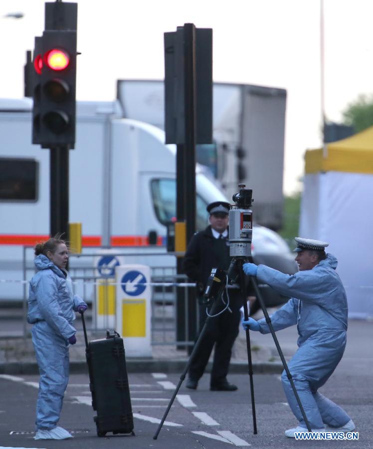 Police forensic officers investigate a crime scene in Woolwich, southeast London May 22, 2013. A man was found dead at the scene and two other men were taken to the hospital in London neighbourhood of Woolwich on Wednesday. (Xinhua/Yin Gang) 