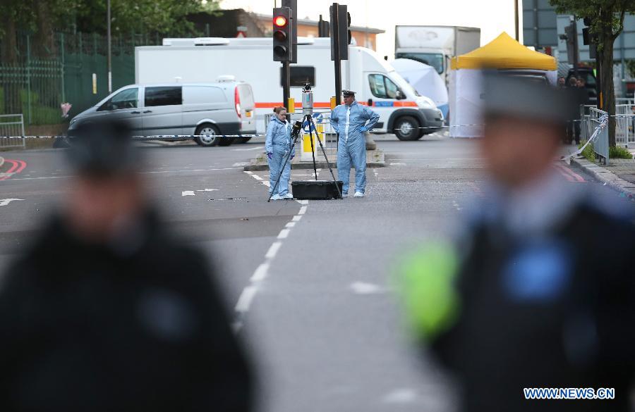 Police forensic officers investigate a crime scene in Woolwich, southeast London May 22, 2013. A man was found dead at the scene and two other men were taken to the hospital in London neighbourhood of Woolwich on Wednesday. (Xinhua/Yin Gang) 