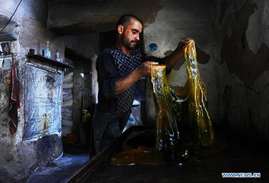 An Afghan man works at a traditional sweet factory in Herat province, western Afghanistan, on May 22, 2013. (Xinhua/Sardar) 