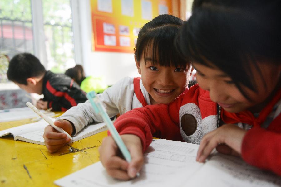 Left-behind children, whose parents go to other places to work, do their homework at an after-school care center in Yanji City, Yanbian Korean Autonomous Prefecture in northeast China's Jilin Province, May 22, 2013. More than 30,000 children are left behind by their parents who choose to go to South Korea to work in the Yanbian Korean Autonomous Prefecture. The local government established 20 after-school care centers to provide these left-behind children with the after-class care. (Xinhua/Lin Hong)