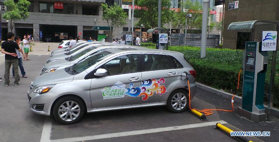 Electric cars get charged at a rental station in the Tsinghua University Science Park in Beijing, capital of China, May 23, 2013. Fifteen electric cars can be rented at the station. There will be 2,000 electric cars for renting in Beijing by the end of this year. (Xinhua/Li Xin)