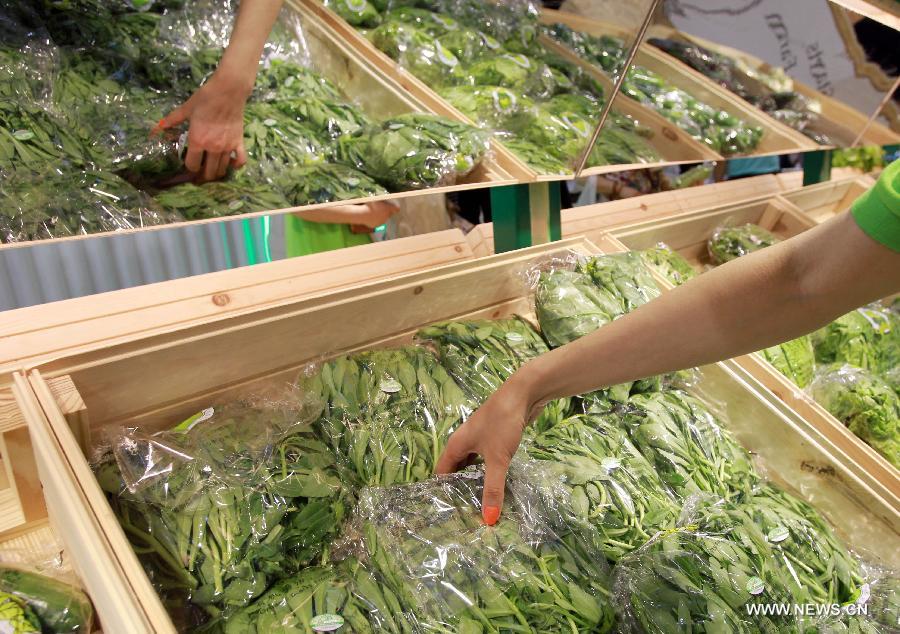 An exhibitor arranges organic vegetables at the 7th International Organic Trade Fair and Conference (BioFach China) in Shanghai, east China, May 23, 2013. The three-day fair, which kicked off on Thursday, attracted 300 exhibitors from more than ten countries and regions. (Xinhua/Ding Ting) 