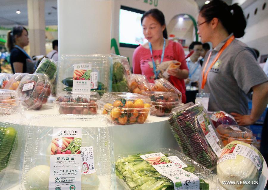 Citizens select organic vegetables at the 7th International Organic Trade Fair and Conference (BioFach China) in Shanghai, east China, May 23, 2013. The three-day fair, which kicked off on Thursday, attracted 300 exhibitors from more than ten countries and regions. (Xinhua/Ding Ting) 