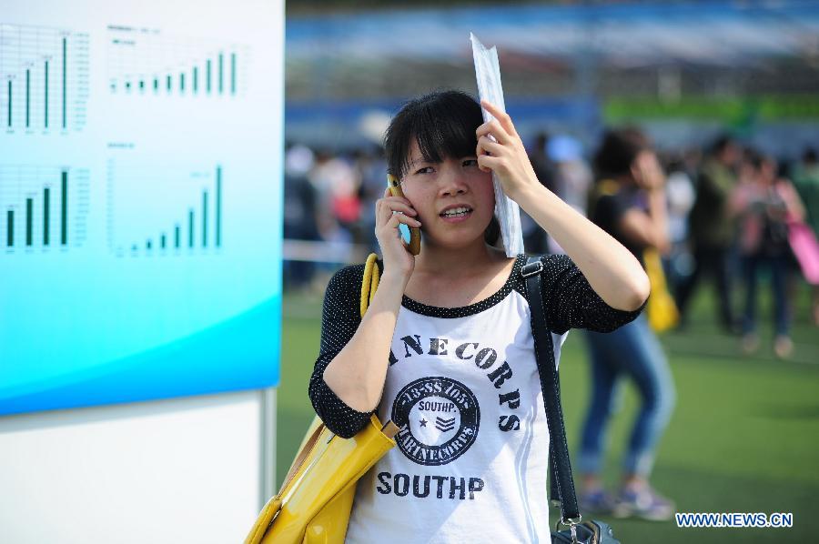 An applicant makes a phone call during a job fair in Guizhou University of Finance and Economics in Guiyang, capital of southwest China's Guizhou Province, May 23, 2013. China will see a record-high 6.99 million people graduate from college this year, up 2.8 percent year on year, according to official figures. (Xinhua/Liu Xu) 