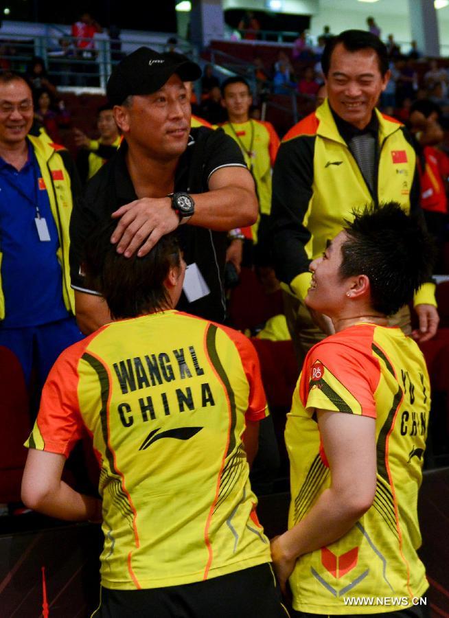 China's Yu Yang (below R) and Wang Xiaoli (below L) gets congratulated by coach Li Yongbo (in black) after the women's doubles badminton match against Indonesia's Natsir Liliyana and Maheswari Nitya Krishinda at the quarterfinals of the Sudirman Cup World Team Badminton Championships in Kuala Lumpur, Malaysia, on May 23, 2013. China won 3-2 to enter the semifinals. (Xinhua/Chong Voon Chung)