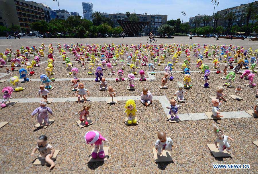 Some "abused" dolls are seen at Rabin Square in Tel Aviv, Israel, on May 23, 2013. Approximately 1,000 dolls, made as if they have been abused, were on a display here to arouse public awareness of child abuse and its long-term effect on those victims. (Xinhua/Yin Dongxun)